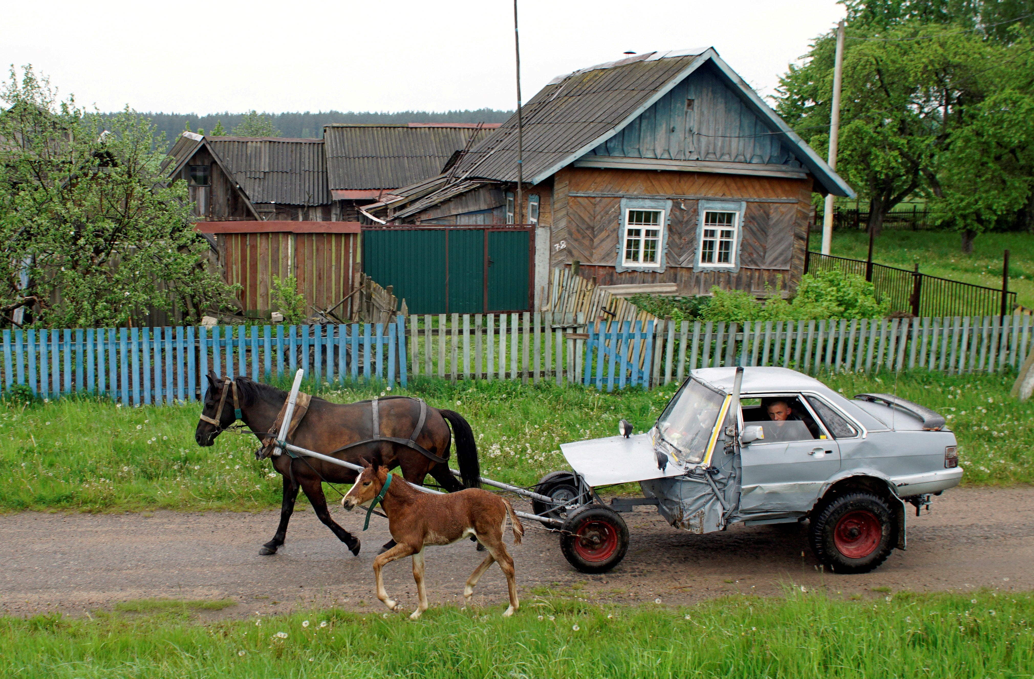 Alexey Usikov, 33, drives a horse-drawn carriage that he crafted out of an old Audi 80 in the village of Knyazhytsy, Belarus, in May