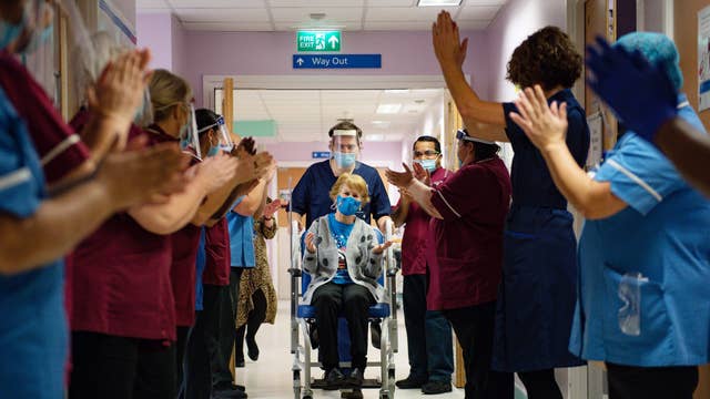 Margaret Keenan, 90, is applauded by staff as she returns to her ward after becoming the first person to receive the Pfizer-BioNtech Covid-19 vaccine at University Hospital in Coventry