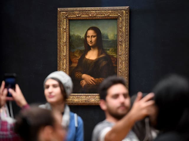 <p>Visitors take selfies in front of the Mona Lisa in 2019</p>