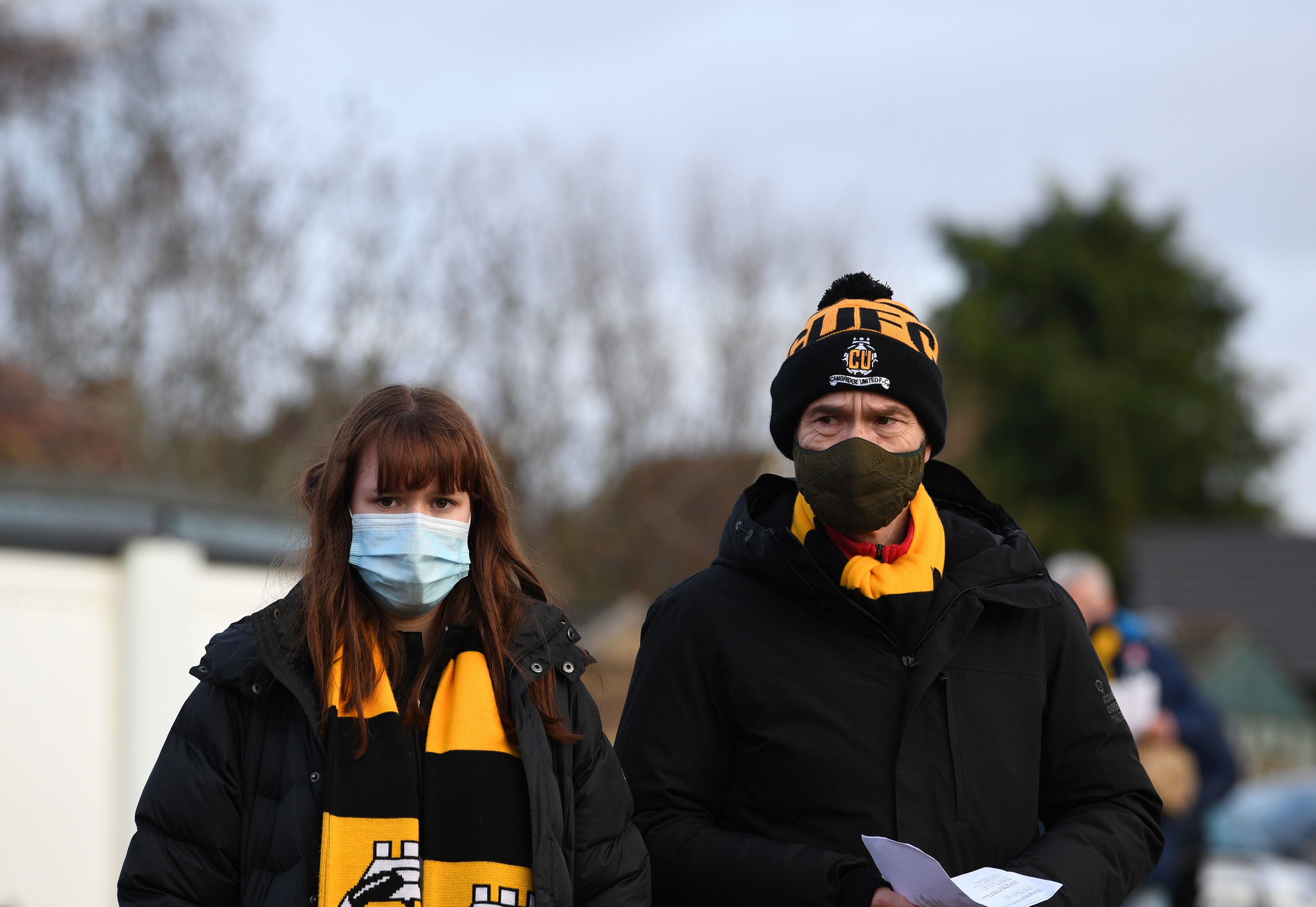 Fans arrive wearing masks to watch a football match at the Abbey Stadium in Cambridge on 5 December, 2020.