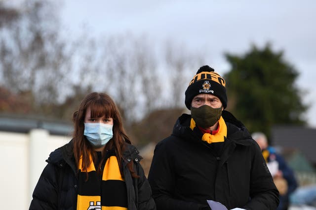 <p>Los fanáticos llegan portando cubrebocas para ver un partido de fútbol en el Abbey Stadium de Cambridge, el 5 de diciembre de 2020.</p>