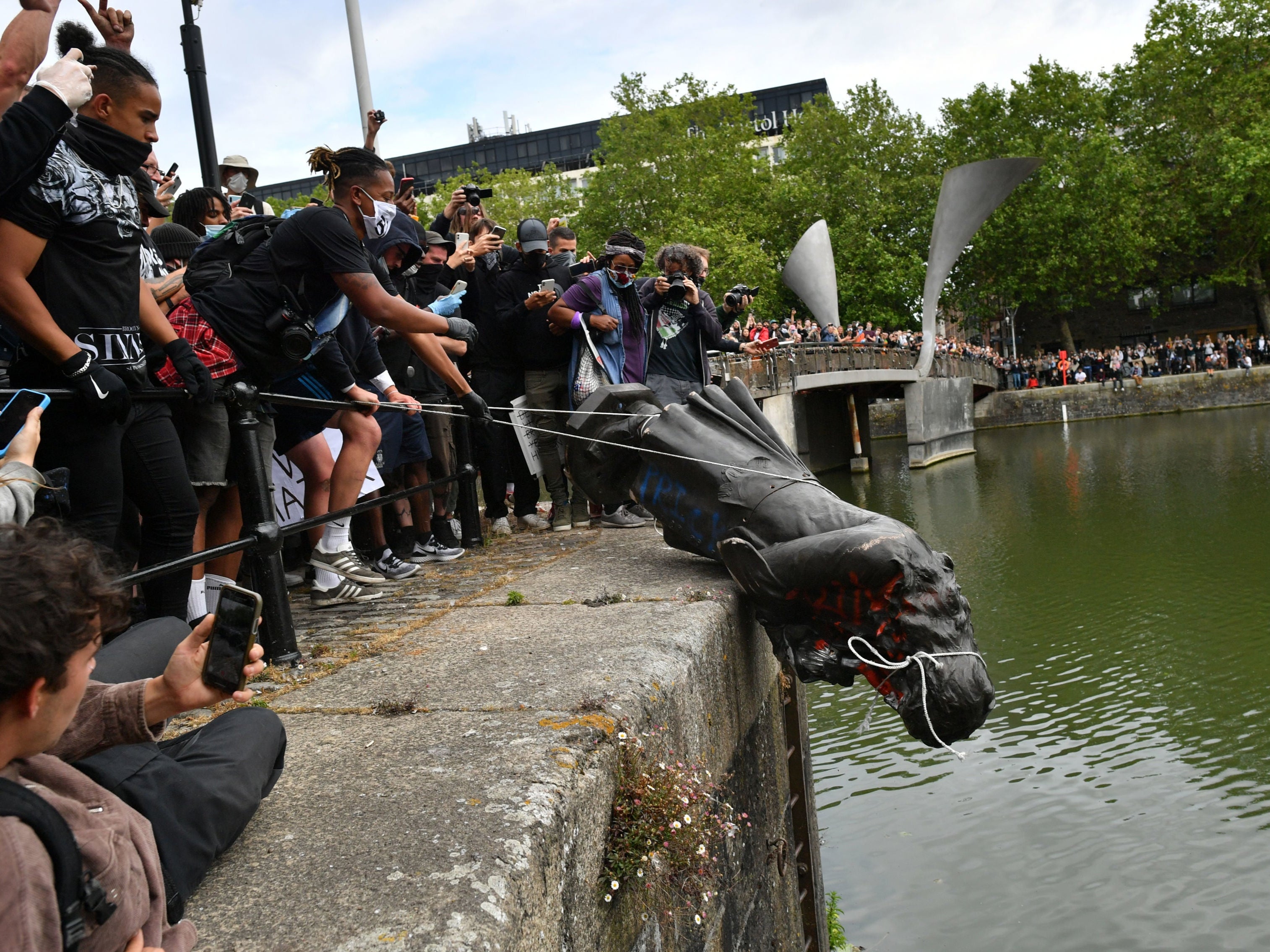 Protesters throw a statue of Edward Colston into Bristol harbour during a Black Lives Matter rally in June last year
