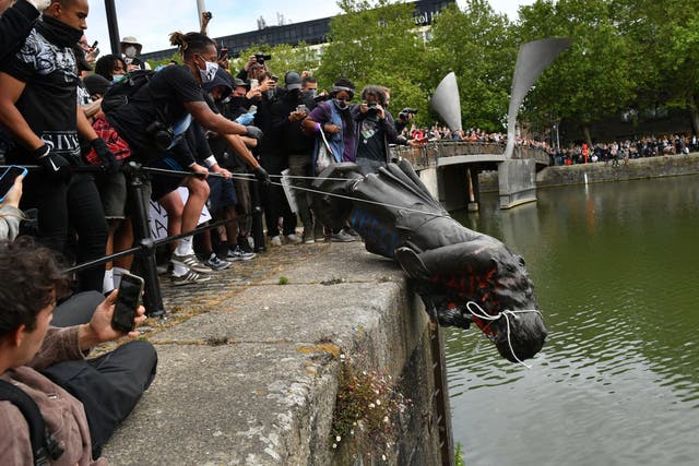 <p>Protesters throw a statue of Edward Colston into Bristol harbour during a Black Lives Matter rally in June last year</p>