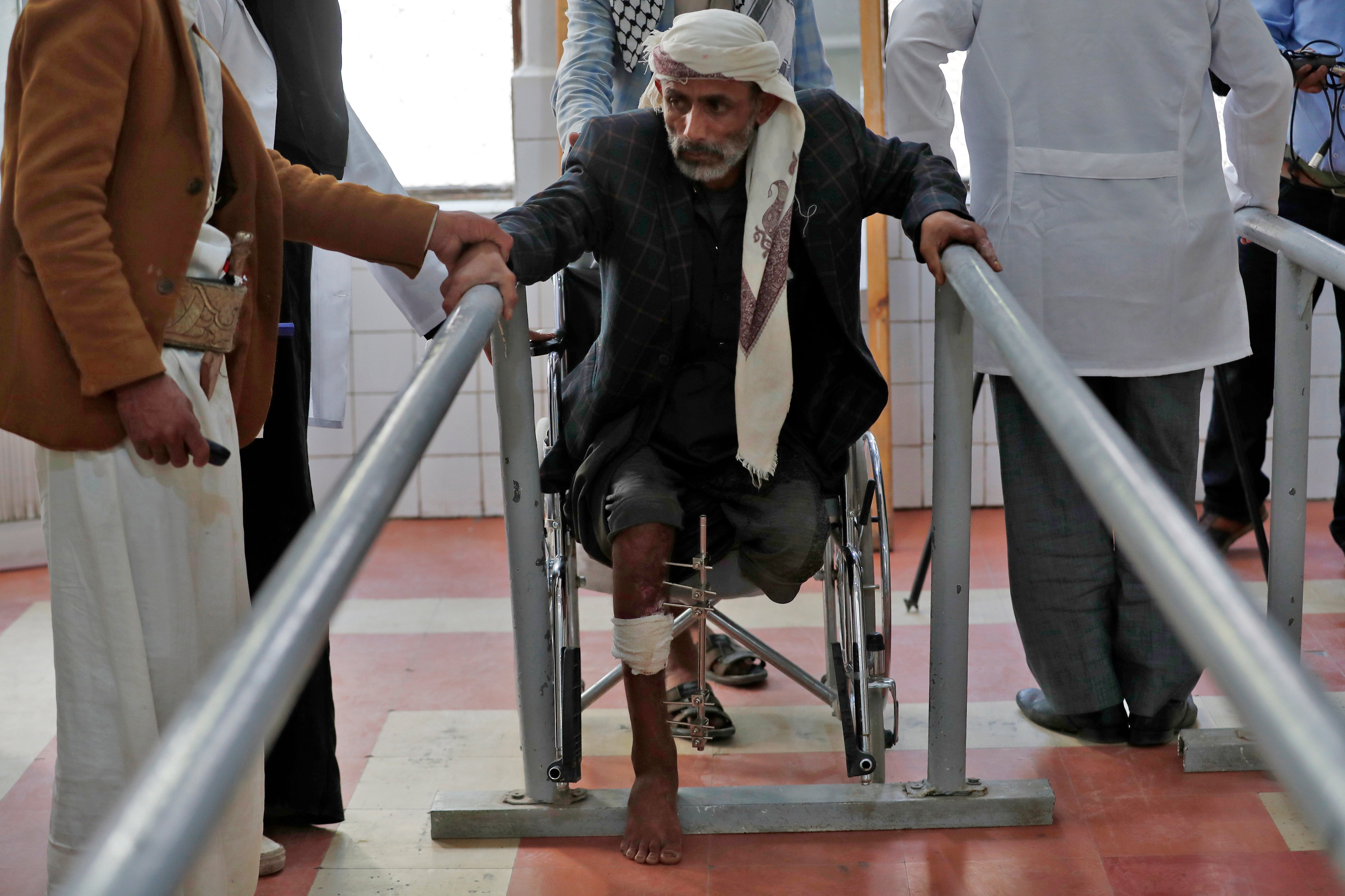 A disabled Yemeni, a victim of the ongoing conflict, tries to stand up as he waits to try out a prosthetic limb at a rehabilitation center in Sana’a