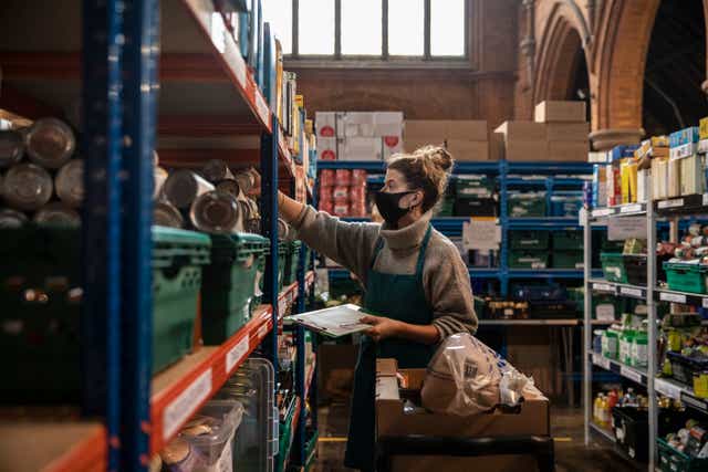 El personal y los voluntarios empacan y preparan paquetes de alimentos en el almacén y centro de distribución del sur de Londres en la iglesia de St Margaret.