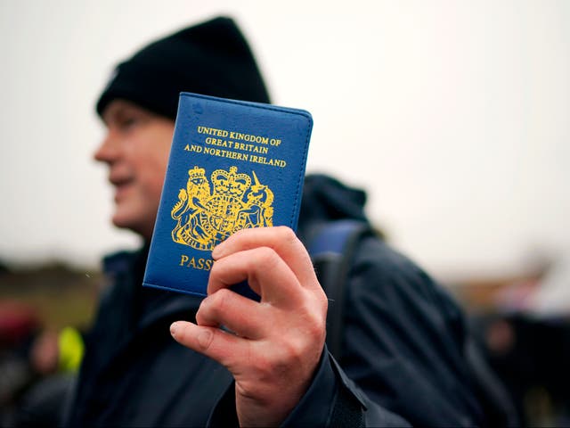 Un partidario de Vote Leave sostiene un pasaporte azul del Reino Unido en la caminata 'March to Leave' en 2019