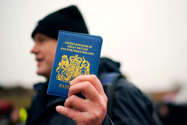 Un partidario de Vote Leave sostiene un pasaporte azul del Reino Unido en la caminata 'March to Leave' en 2019
