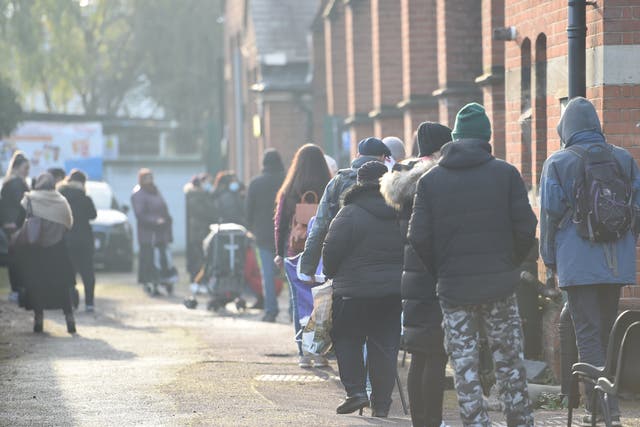 <p>Service users queue at Green Lanes food bank in north London</p>