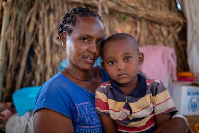 A woman with her son aged four, in UM Rakuba refugee camp in Sudan—they have received a monthly ration from WFP, including sorghum, oil, salt and millet