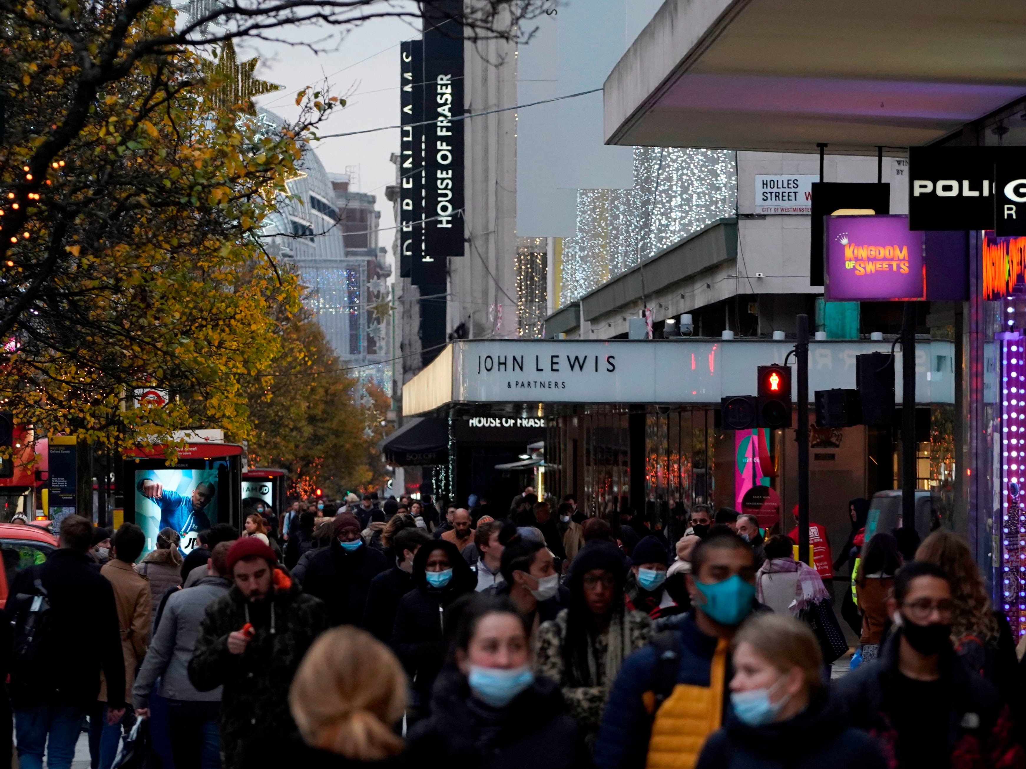 <p>Shoppers and pedestrians walk along Oxford Street as lockdown ends</p>