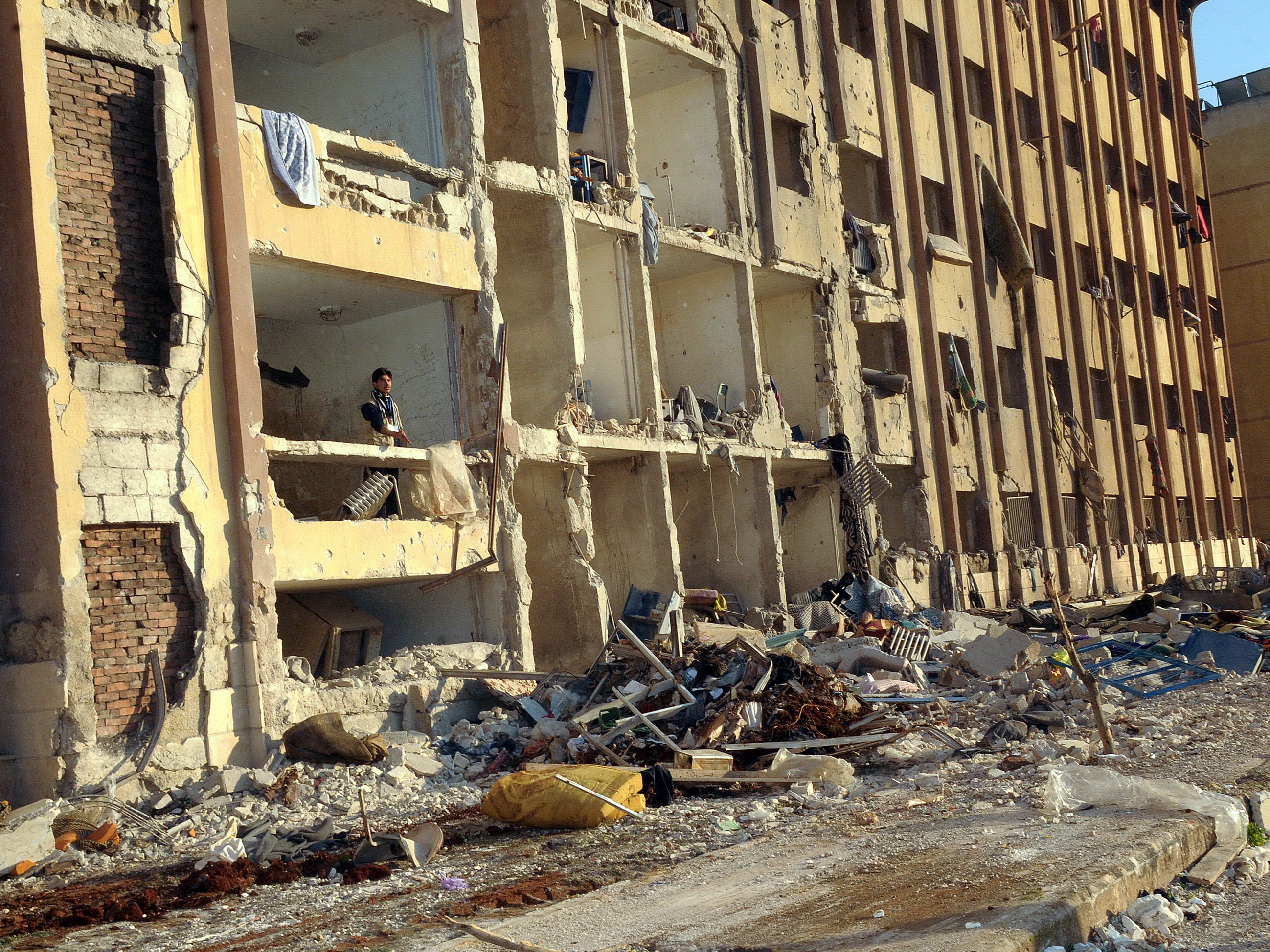 A Syrian man stands in the debris following an explosion outside Aleppo University in January 2013