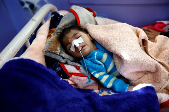 A malnourished child with a feeding tube lies on a bed as he gets medical attention at a hospital in Yemen