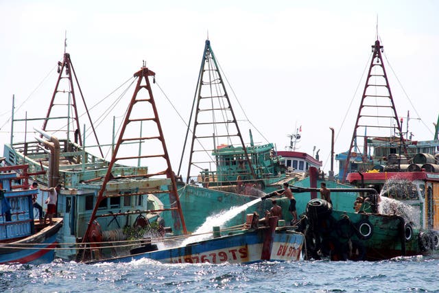 Workers fill Vietnamese fishing boats with water to sink them after they were seized due to illegal fishing in Indonesia's waters, at Datuk island in West Kalimantan, Indonesia