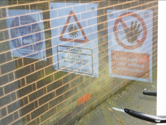 Signage giving Covid-19 related guidance is seen on doors at a primary school