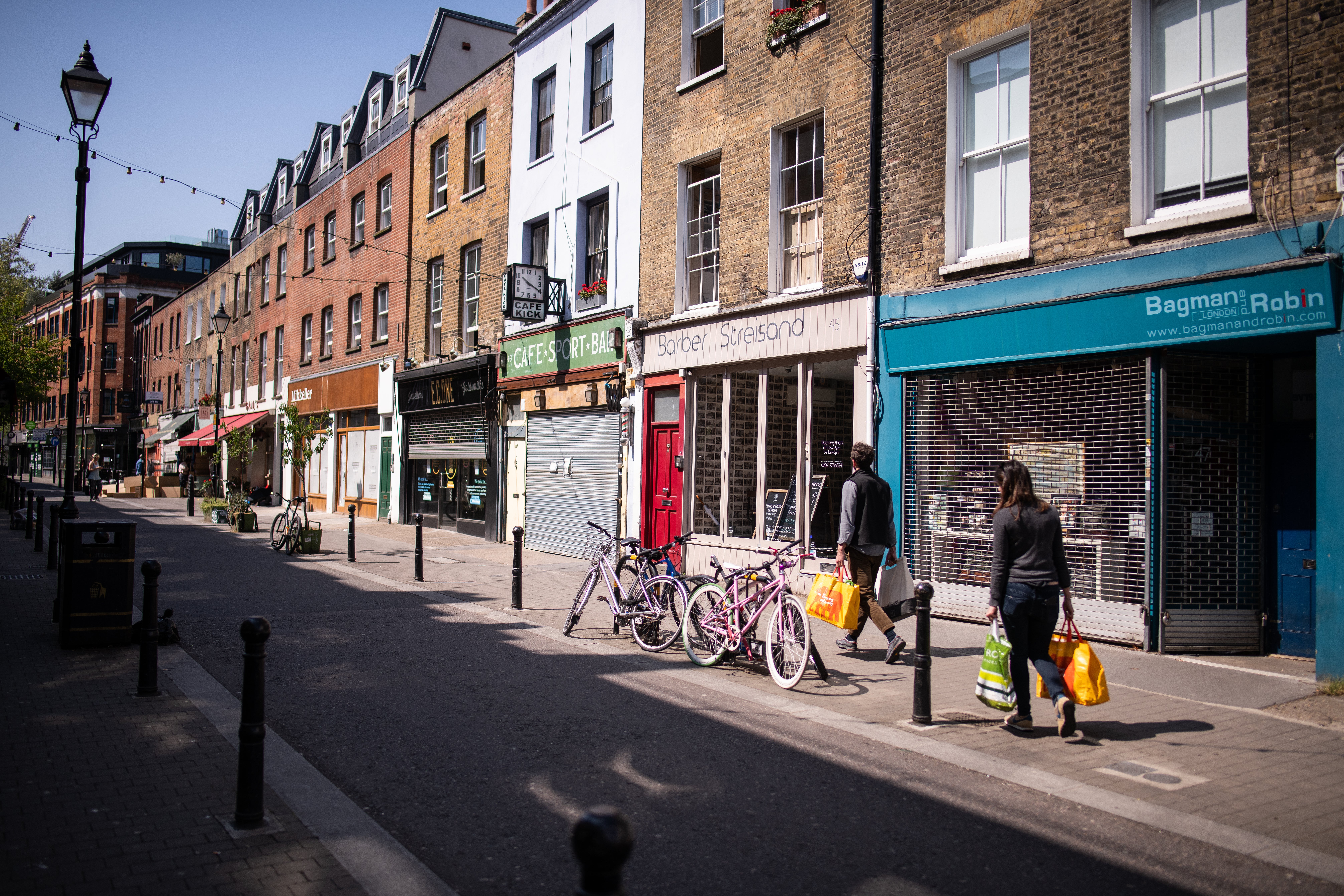A man and woman carry their shopping down the usually busy Exmouth Market in London