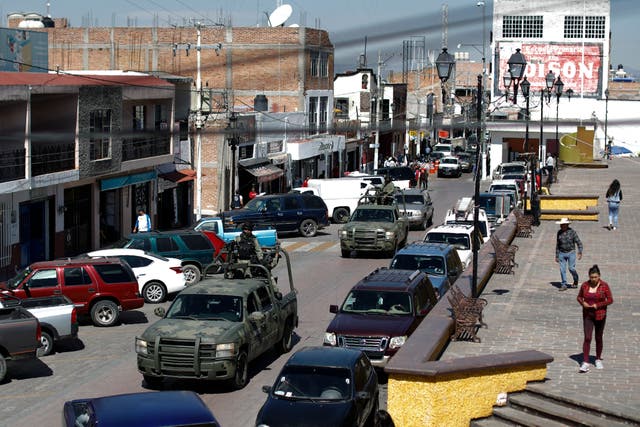 National Guard patrol vehicles drive through the central square in Apaseo el Alto, Guanajuato state, Mexico. The two most powerful drug cartels in the hemisphere are battling over this industrial and farming hub. (AP Photo/Rebecca Blackwell, File)