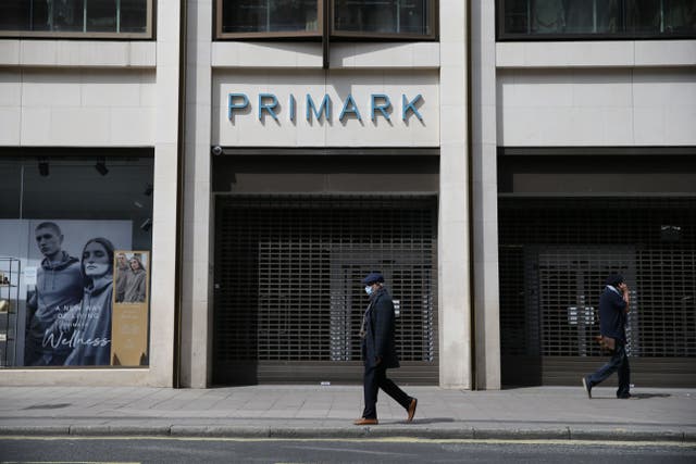 <p>A masked man walks past a closed Primark store in London’s Oxford Street in May 2020</p>