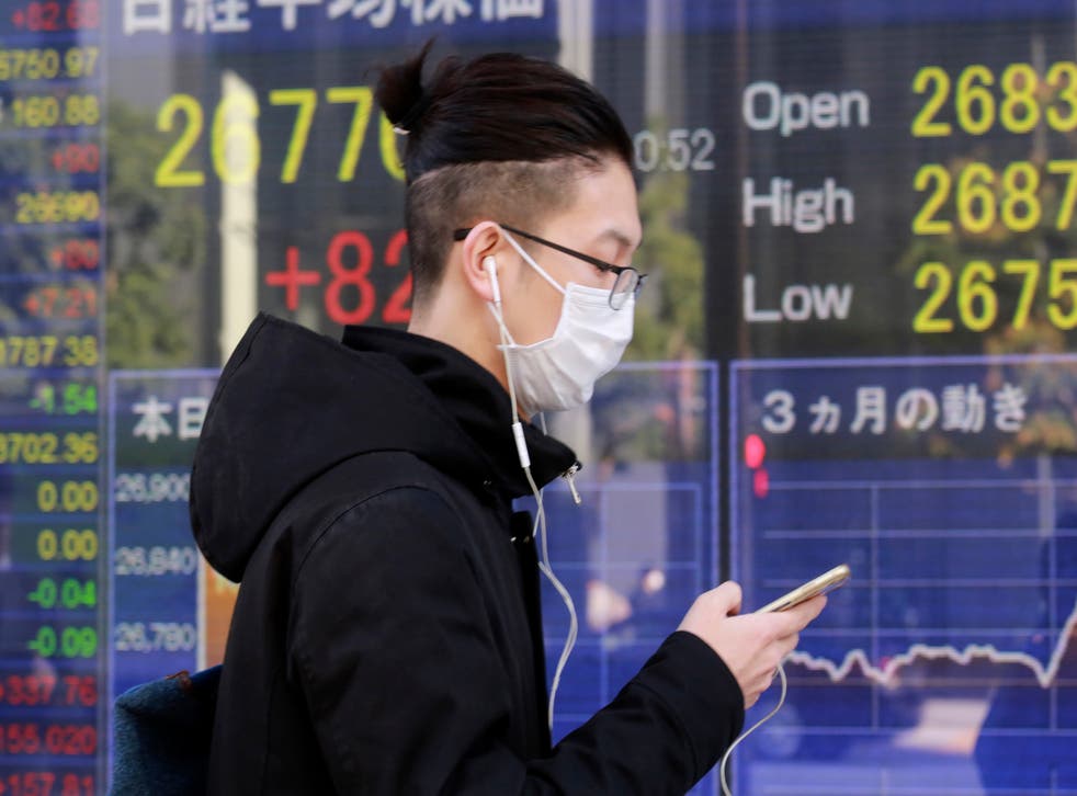 <p>Una persona frente a una cartelera financiera en Tokio el 16 de diciembre del 2020. </p>