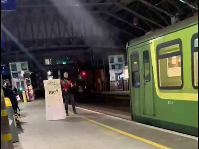 <p>Conor O’Sullivan waits with flowers at Pearse Station in Dublin</p>