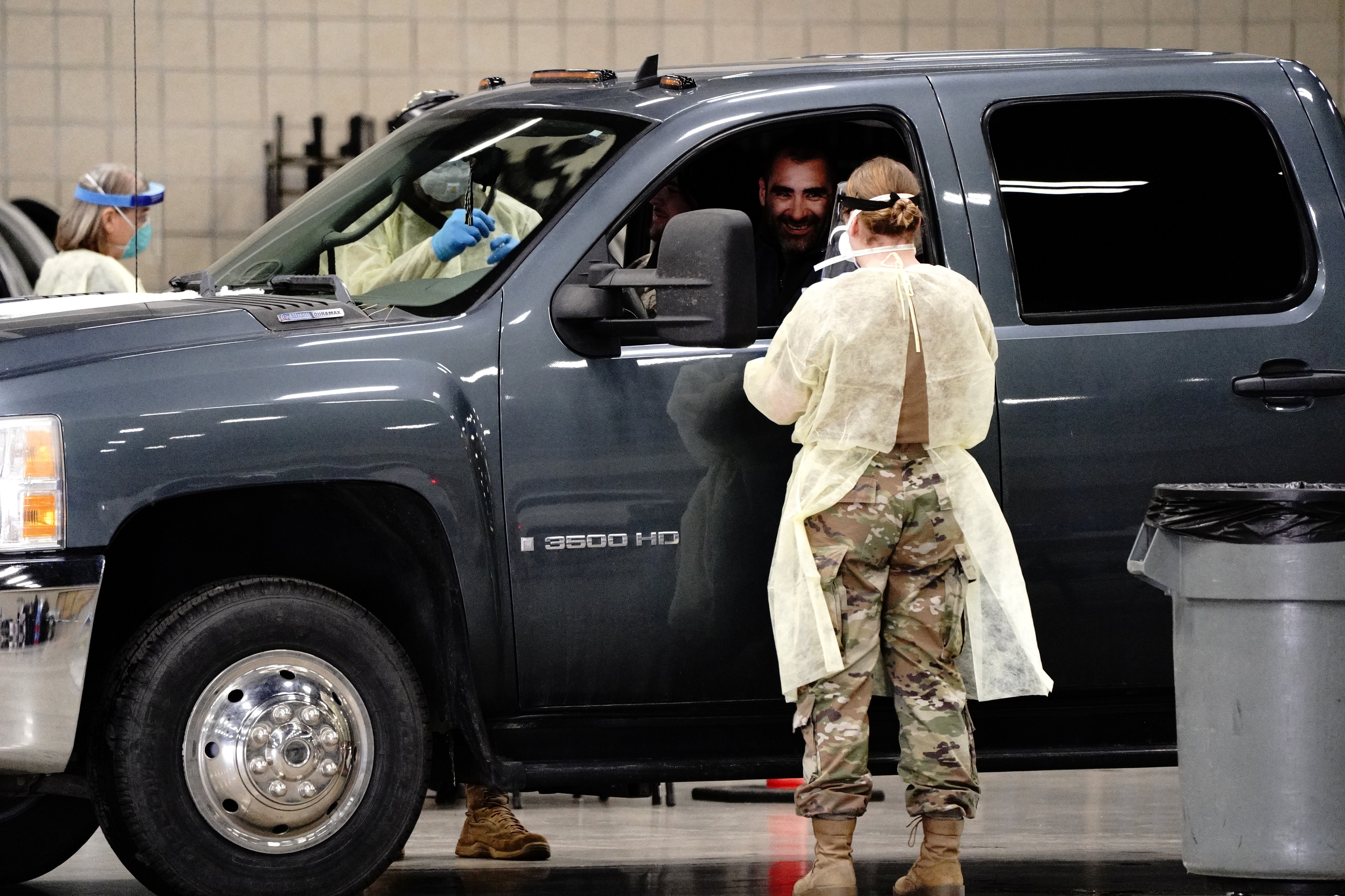 A man prepares to receive a throat swab from a North Dakota National Guard soldier at a drive-thru testing site inside the Bismarck Event Centre, 26 October 2020