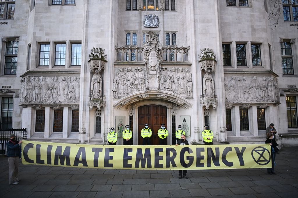 Campaingers against a proposed third runway at Heathrow hold placards outside the Supreme Court in London