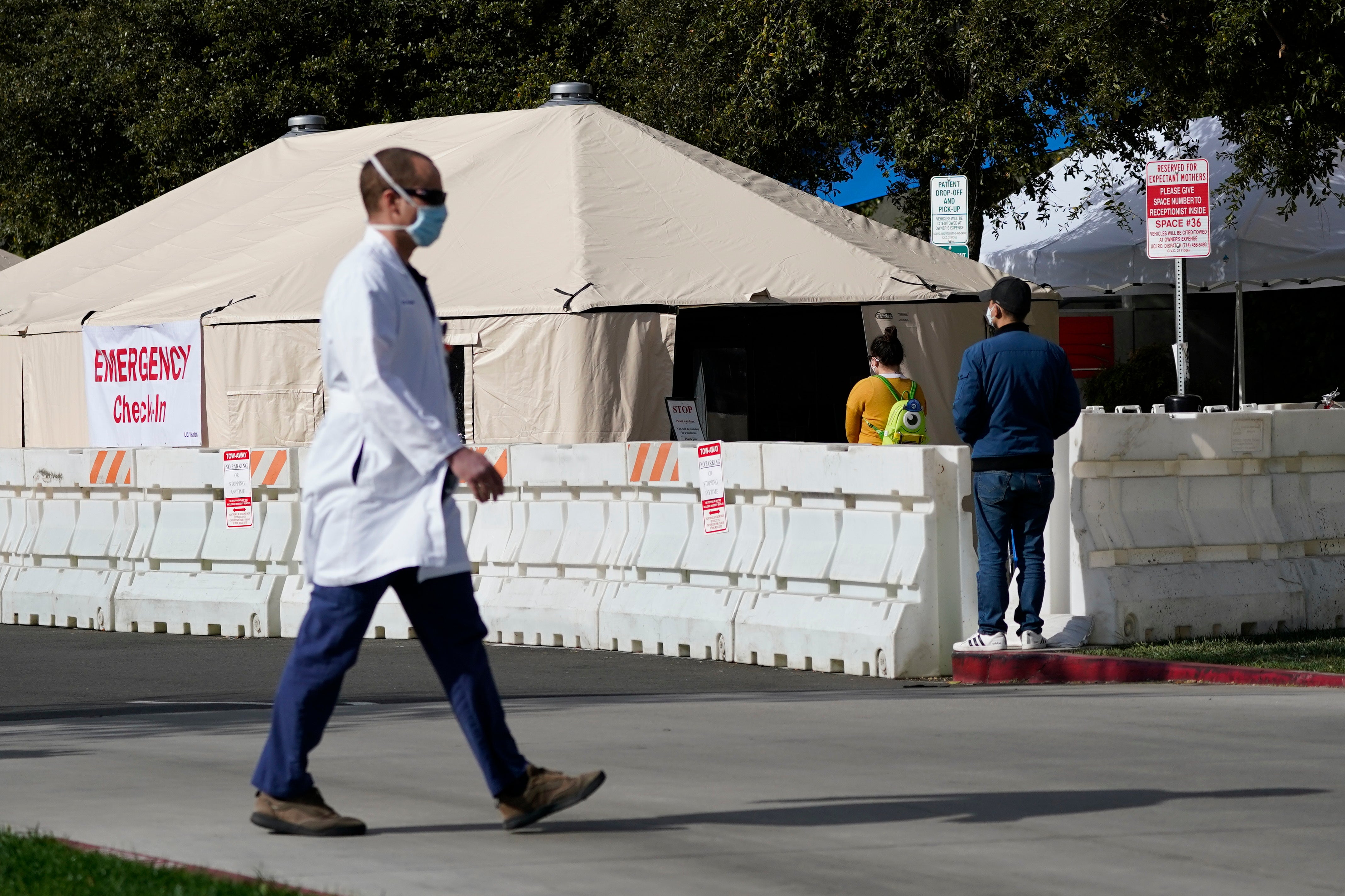 A health worker passes a medical tent outside the emergency room at UCI Medical Center in Irvine, California on 17 December.