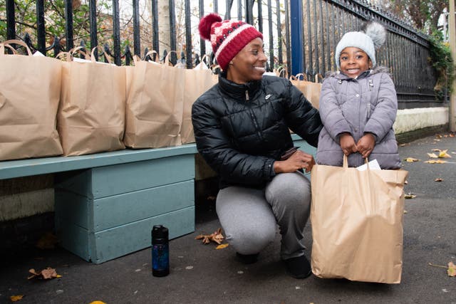 <p>A family receives a breakfast box at a school in Southwark, thanks to the Unicef UK-funded project School Food Matters</p>