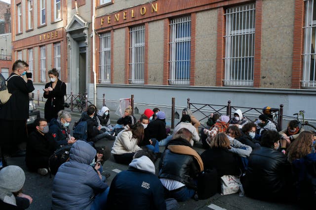 Students stage a sit-in outside the Fenelon High School in Lille, northern France, Friday, 18 December 2020