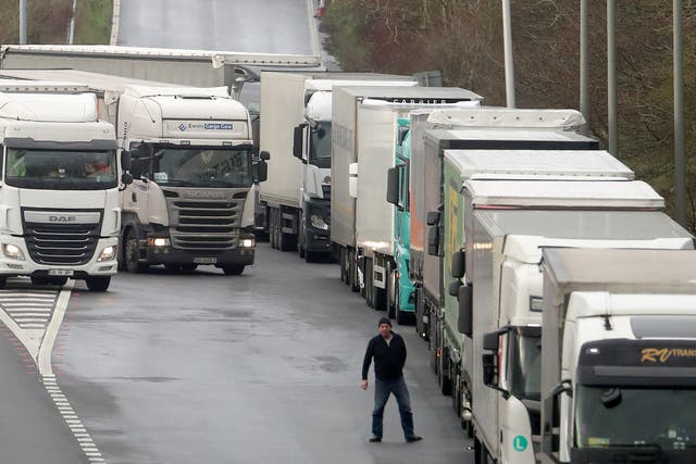 <p>A driver views the queue of lorries on the M20 as trucks wait to enter the Eurotunnel site in Folkestone, Kent, due to heavy freight traffic</p>