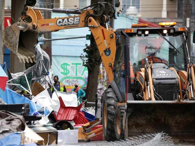 Workers use a bulldozer to remove remaining items from an encampment outside the Seattle Police Department’s East Precinct after police cleared the Capitol Hill Occupied Protest (CHOP) in Seattle, Washington on 1 July, 2020
