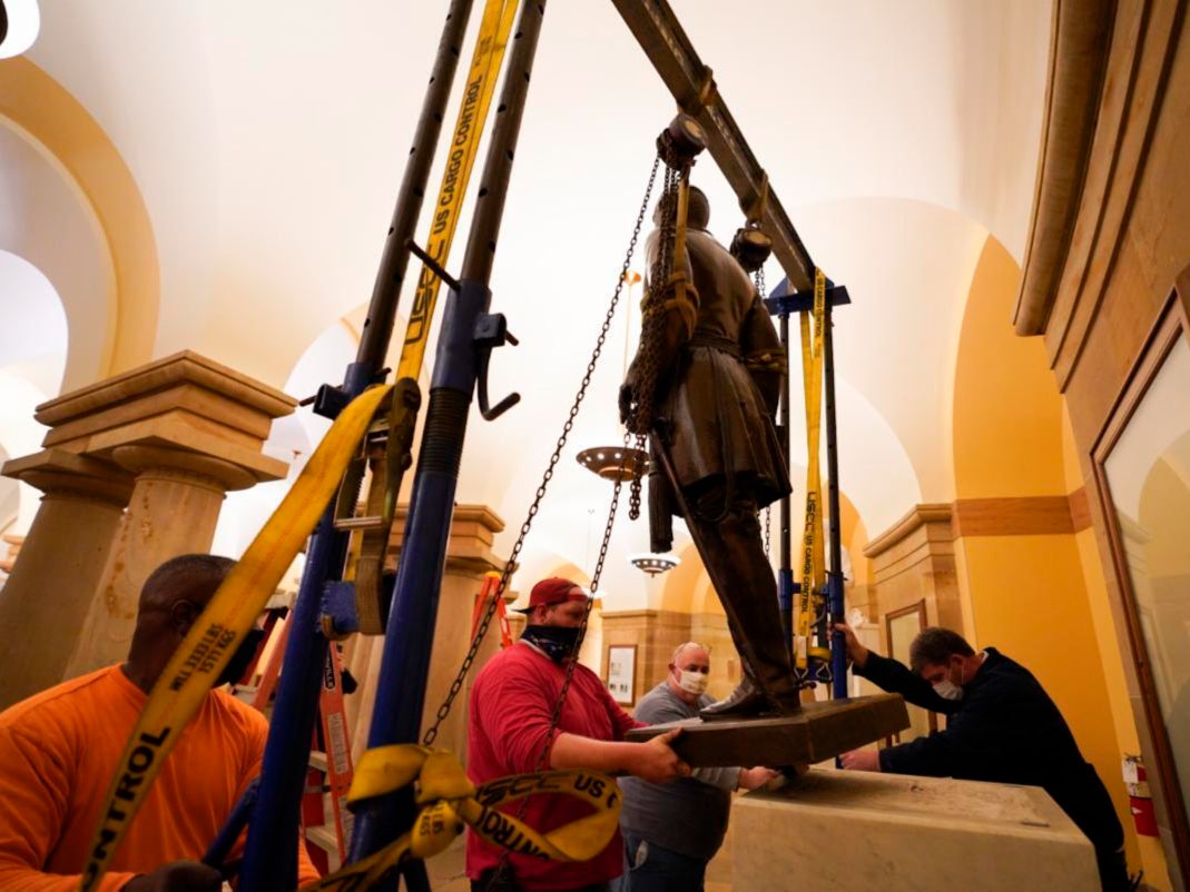 This Monday, 21 December 2020 photo provided by the Office of the Governor of Virginia shows workers removing a statue of Confederate Gen. Robert E Lee from the National Statuary Hall Collection in Washington
