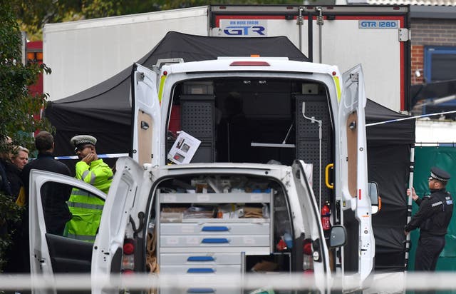 Police officers working near the lorry that contained 39 dead bodies