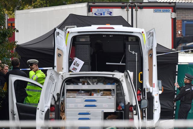 Police officers working near the lorry that contained 39 dead bodies