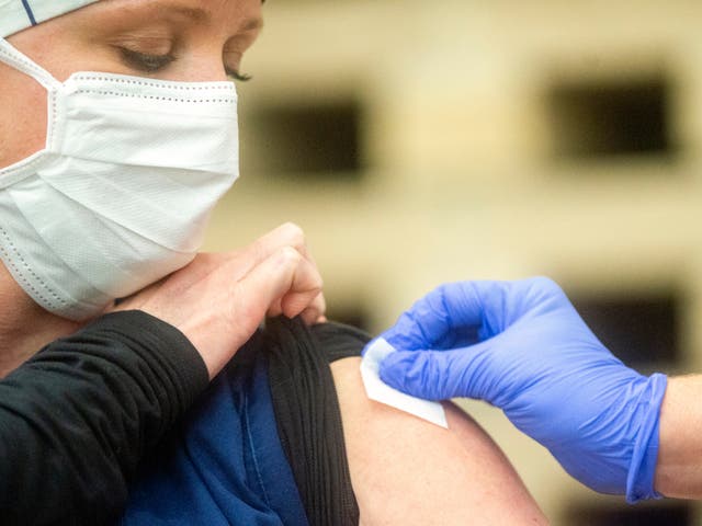 <p>Kellie Johnson, a respiratory therapist, receives the Pfizer Covid-19 vaccine.</p>