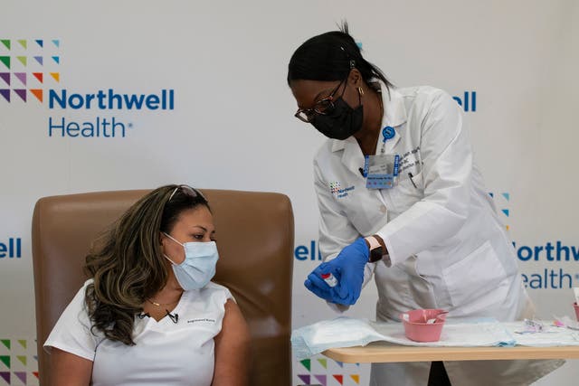 <p>A woman is administered with the vaccine by a medical professional at Northwell Health</p>