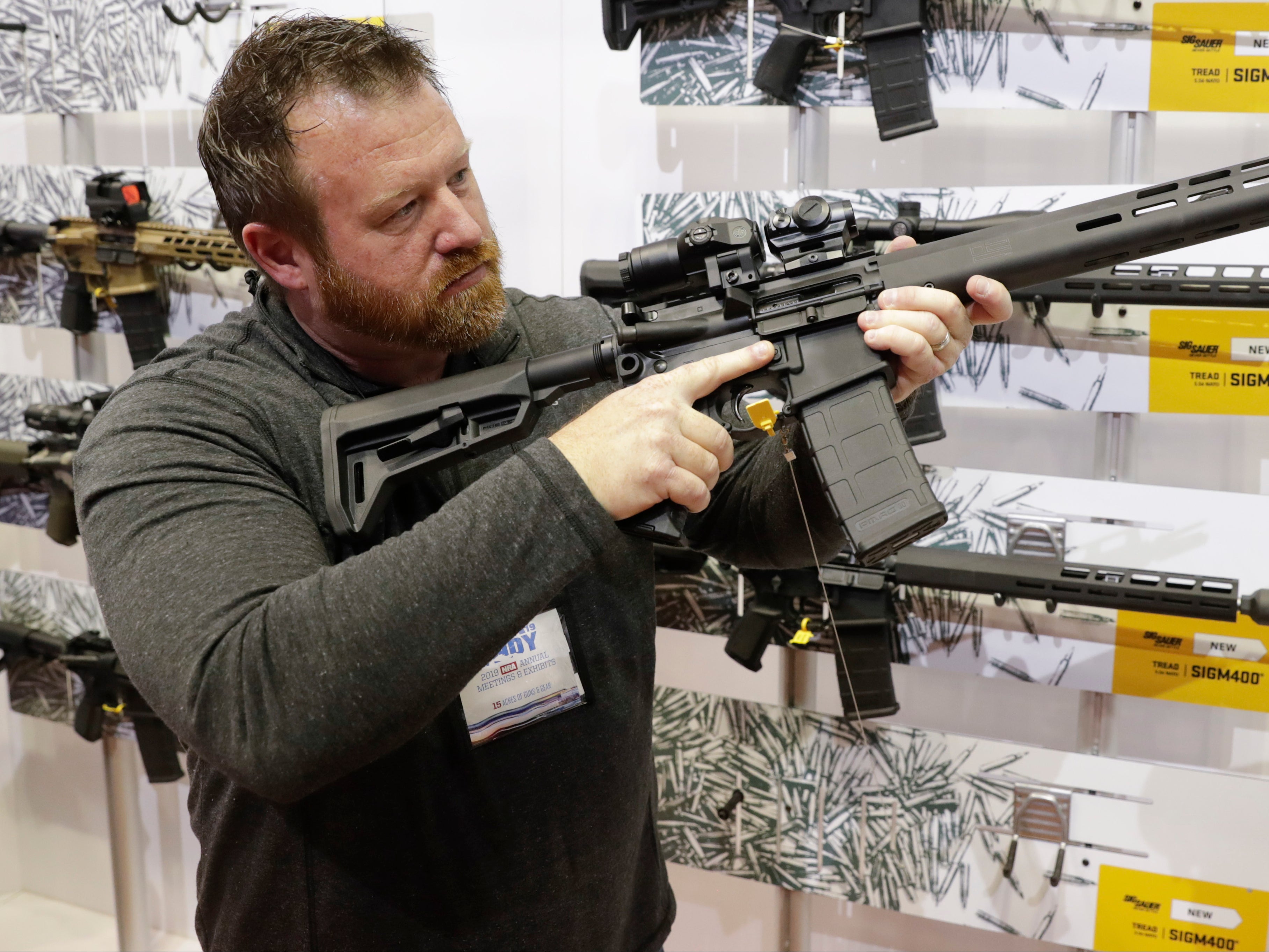 Bryan Oberc, Munster, Ind, tries out an AR-15 from Sig Sauer in the exhibition hall at the National Rifle Association Annual Meeting in Indianapolis