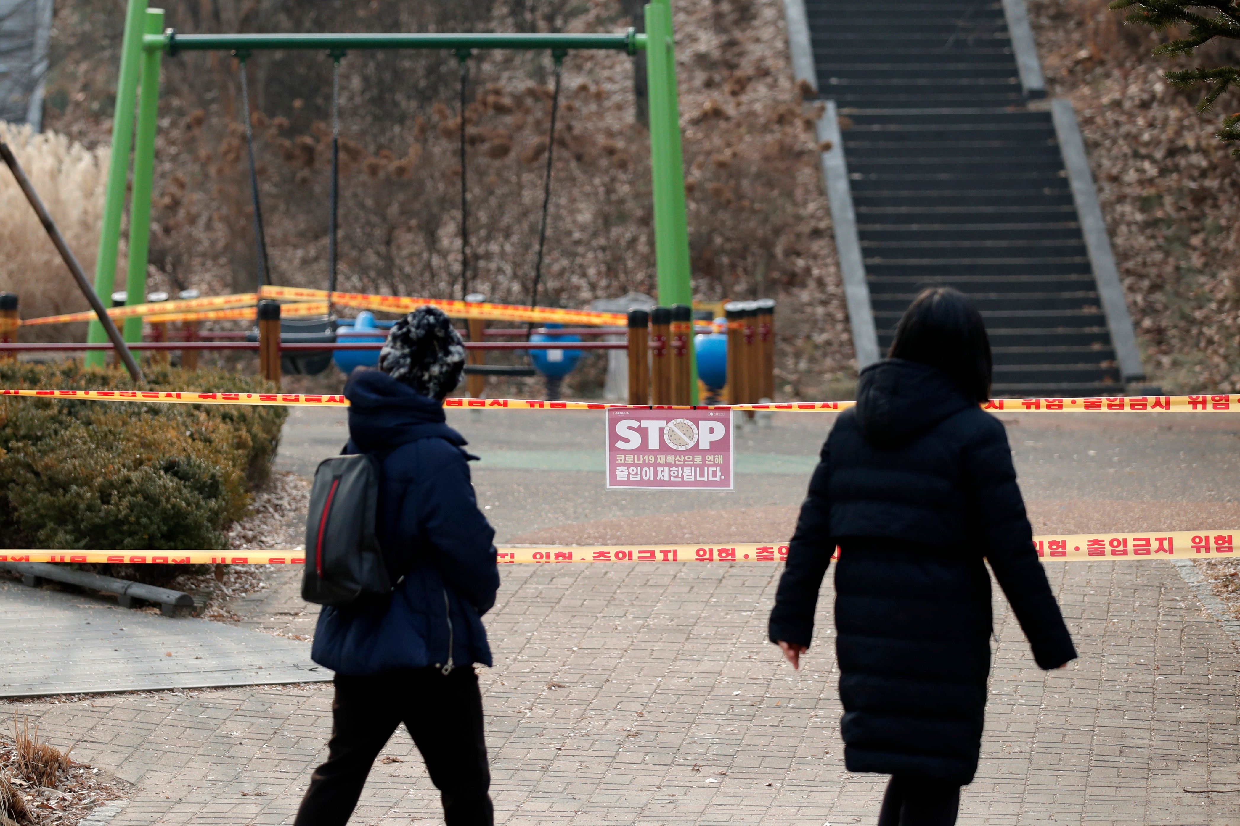 Visitors look at a playground, which is taped off for the social distancing measures, to control the spread of coronavirus at a park in Seoul, South Korea.