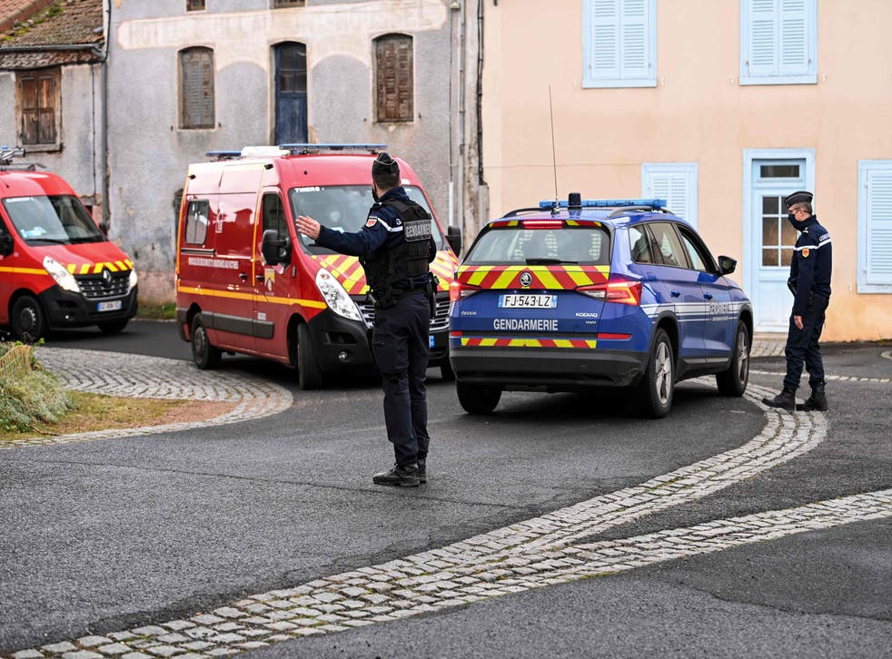 <p>A gendarme directs traffic near a house where three police officers were shot dead when responding to an incident in Saint-Just on Wednesday</p>