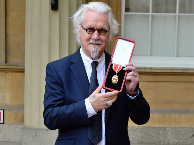 <p>British comedian Billy Connolly poses with his medal after being knighted in 2017</p>