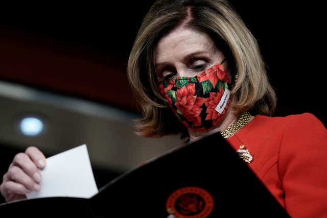 Speaker of the House Nancy Pelosi (D-CA) reads papers as Senate Minority Leader Charles Schumer (D-NY) (not pictured) speaks to reporters on an agreement of a coronavirus disease (COVID-19) aid package on Capitol Hill in Washington, DC, on 20 December 2020