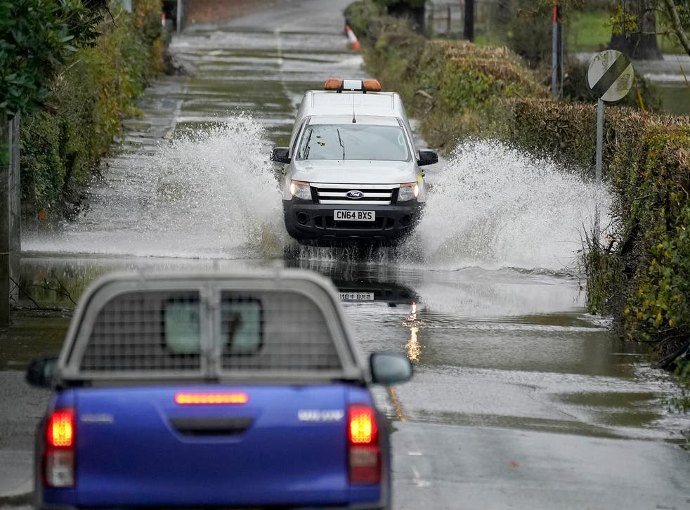 Cars drive on a flooded road as the River Conwy bursts its banks on October 30, 2020 in Llanrwst, Wales. Parts of Wales have been flooded again after heavy rains overnight.