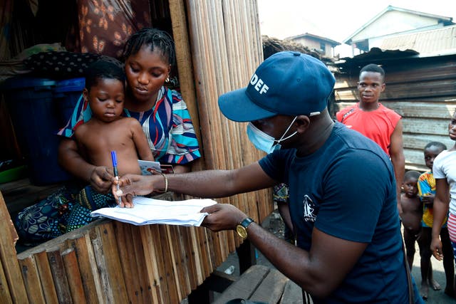 A family receives a pre-paid debt card for cash and food provided by World Food Programme in the Makoko riverine slum settlement in Lagos on 27 November, 2020. The WFP has round off cash and food assistance across the country to most vulnerable people to cushion the effect of Covid-19 pandemic. 