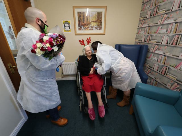 <p>Mary Orme and her son Michael McKimm embrace their mother and grandmother, Rose McKimm, during a Christmas Day visit at Aspen Hill Village care home</p>