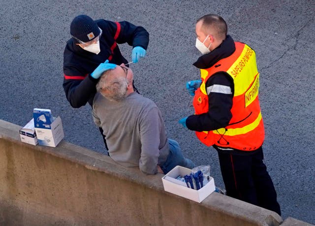 <p>Members of the French Fire Service swab a lorry driver for a Covid-19 test at the Port of Dover</p>