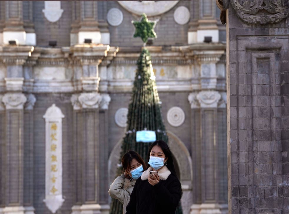 <p>Unas personas posan para una fotografía afuera de la iglesia de Wangfujing, en Beijing, el viernes 25 de diciembre de 2020.&nbsp;</p>