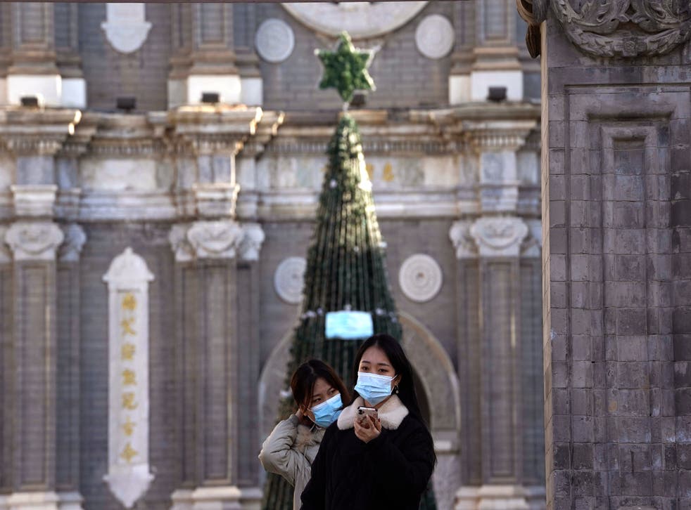 <p>Unas personas posan para una fotografía afuera de la iglesia de Wangfujing, en Beijing, el viernes 25 de diciembre de 2020. </p>