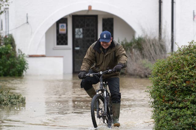 A man cycles through flood water at The Barn Hotel in Bedford on 26 December