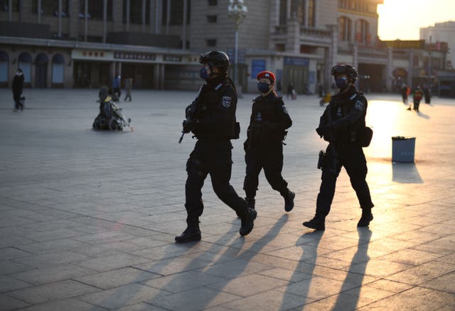 Policemen, wearing protective facemasks, patrols around Beijing Railway Station on 30 January, 2020. A knife attack in the city of Kaiyuan in Liaoning province has left seven dead, according to state media.