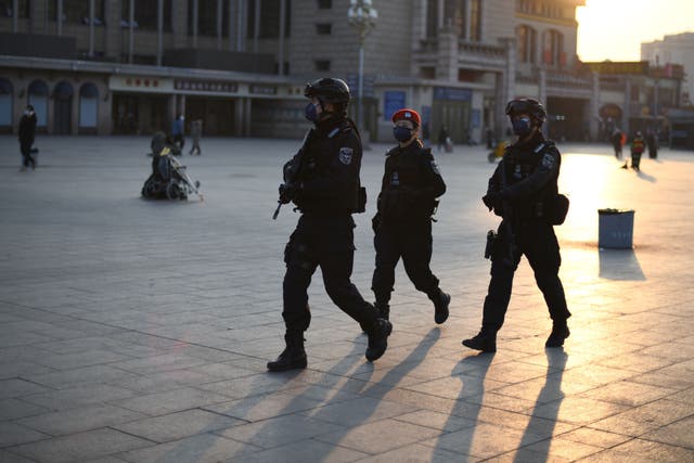 Policemen, wearing protective facemasks, patrols around Beijing Railway Station on 30 January, 2020. A knife attack in the city of Kaiyuan in Liaoning province has left seven dead, according to state media.