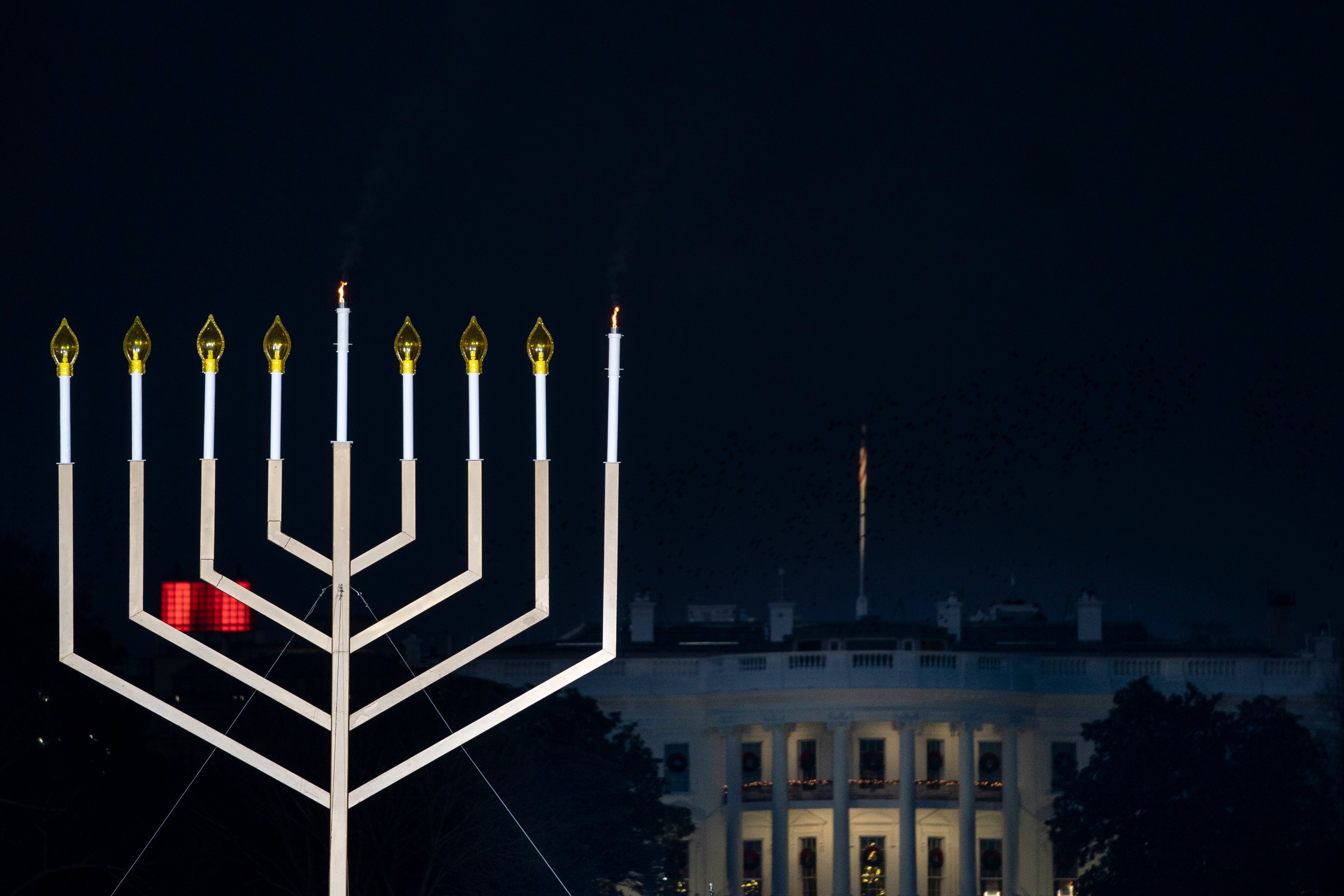 The White House is seen behind the newly lit National Menorah during a ceremony in President’s Park just south of the White House on 10 December, 2020